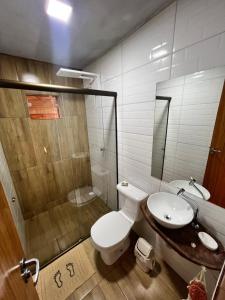 ein Bad mit einem WC, einem Waschbecken und einer Dusche in der Unterkunft Recanto dos Pássaros in Caparaó Velho
