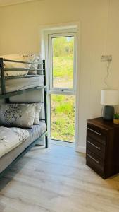 a bedroom with a bunk bed and a window at Couston Lakes Resorts in Bathgate