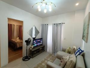a living room with a couch and a flat screen tv at 2bedrooms 2toilet& bath Matina Enclaves Condo in Davao City