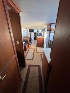 a hallway of a room with a door and a kitchen at 60ft Stationary House Boat in New Baltimore +22 photos