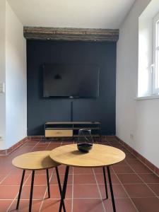 a room with two tables and a tv on a wall at Ferienwohnung Hohwacht Ostsee in Hohwacht