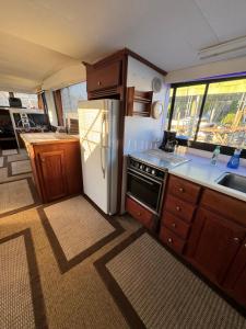 a kitchen with a white refrigerator and wooden cabinets at 60ft Stationary House Boat in New Baltimore