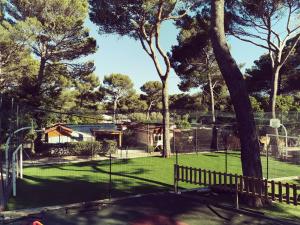 a house with a tennis court in a yard at Mobil home 6 pers - camping Les Arbouses - clim terrasse plancha in Le Castellet