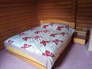 a bed with red butterflies on it in a room at Закарпатский сруб in Krasna