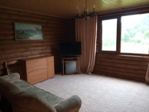 a living room with a couch and a television at Закарпатский сруб in Krasna