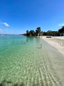 a group of people in the water at a beach at LA CASA SA TRINXA - 300 m des plages - Pointe de Beg-Meil in Fouesnant