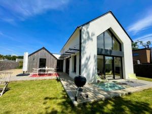 a modern house with a deck and yard at LA CASA SA TRINXA - 300 m des plages - Pointe de Beg-Meil in Fouesnant