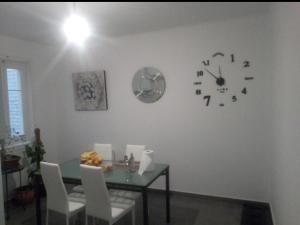 een eetkamer met een tafel en een klok aan de muur bij - Habitación comp Masculina in Madrid +11 foto's