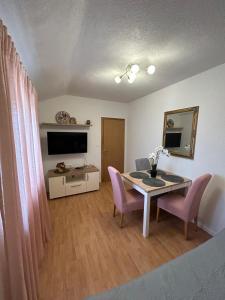 sala de estar con mesa y sillas rosas en Apartment Lovre Topic, en Baška Voda
