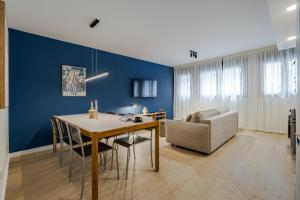 a dining room with blue walls and a table and a chair at Puerto Alto Apartments by Olala Homes in Madrid