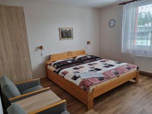 1 dormitorio con 1 cama y 1 silla en Ubytování Šustovka, en Třeboň