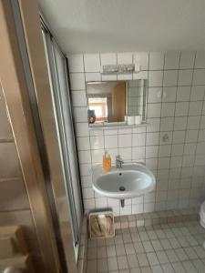 a bathroom with a sink and a mirror at Pension Döser Strand in Cuxhaven