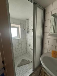 a bathroom with a shower and a sink at Pension Döser Strand in Cuxhaven