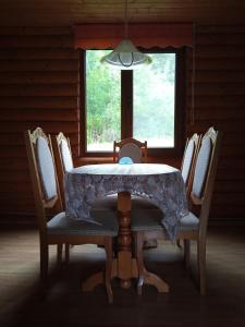 a dining room table with chairs and a window at Закарпатский сруб in Krasna