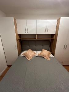 1 dormitorio con 1 cama con armarios blancos y 2 almohadas en Apartment Lovre Topic, en Baška Voda