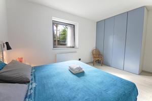 a bedroom with a bed with a blue blanket at Casa Didi & Rosi - Lake Como in Colico
