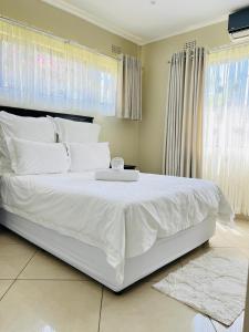 uma grande cama branca com uma bandeja em cima em Langelihle- Margate Accommodation em Margate