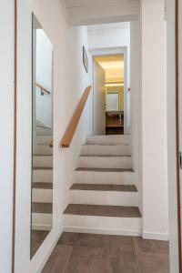 una escalera en una casa con espejo en Landhaus Lifestyle, en Rezzonico