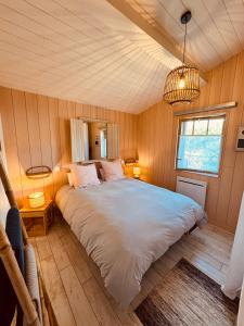 um quarto com uma cama grande num quarto em La cabane de Mamie classée 4 étoiles à 150m de la plage 2 chambres 3 lits em Biscarrosse-Plage