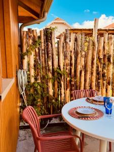 uma mesa e cadeiras num pátio com uma cerca em La cabane de Mamie classée 4 étoiles à 150m de la plage 2 chambres 3 lits em Biscarrosse-Plage