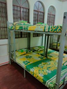 two bunk beds sitting in a room with at Mang Ben Dormitory Kaliraya in Manila
