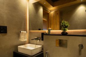 a bathroom with a white sink and a mirror at SaffronStays Aruunoday - Villa 4 bhk and 1 room Suite in Bhīm Tāl +49 photos