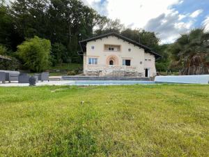 a house with a pool in front of a yard at AU PETIT CHENE in Aire-sur-lʼAdour
