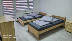 two twin beds in a room with a table at Apatament LISEK in Lisów