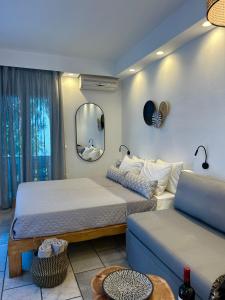 Habitación con 2 camas, sofá y espejo. en Sea View Apartments & Studios en Agia Anna Naxos