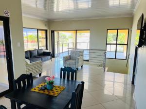 a dining room with a table and chairs and a couch at Langelihle- Margate Accommodation in Margate