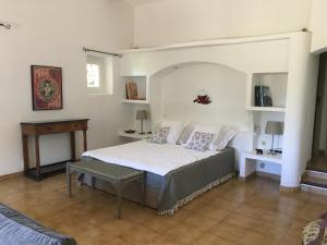 a bedroom with a bed and a table in it at L'Atelier de la Baronnie - Lubéron in Cabrières-dʼAvignon +36 photos