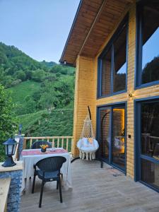 a patio with a table and chairs on a house at Heyamoo Tatil Köyü in Çamlıhemşin