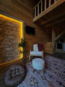 a living room with a chair and a ottoman at Heyamoo Tatil Köyü in Çamlıhemşin