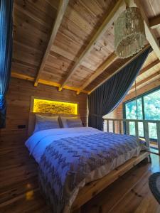 a bedroom with a bed in a wooden house at Heyamoo Tatil Köyü in Çamlıhemşin