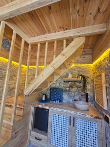 a kitchen with a wooden ceiling with a tv in a room at Heyamoo Tatil Köyü in Çamlıhemşin