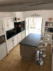 a kitchen with a black counter and white cabinets at L'Atelier de la Baronnie - Lubéron in Cabrières-dʼAvignon