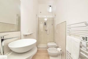 a white bathroom with a sink and a toilet at Terrazza nel Corso-City center in Piombino +12 photos