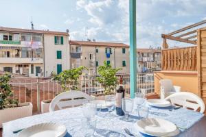 a table with plates and glasses on a balcony at Terrazza nel Corso-City center in Piombino