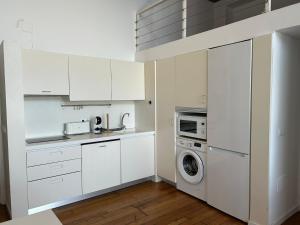 a kitchen with white cabinets and a washer and dryer at Smile Seaview in Nerja