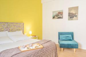 a bedroom with a bed and a blue chair at Terrazza nel Corso-City center in Piombino