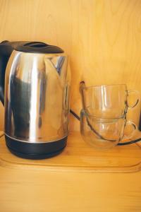 a tea kettle and a glass bowl on a wooden shelf at Panorama Glamping in Saty