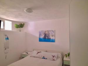 - une chambre avec un lit et une peinture murale dans l'établissement Ponza Le Forna, à Ponza