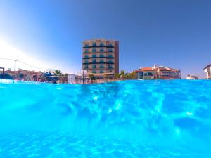duży niebieski basen z budynkiem w tle w obiekcie Hotel Musho w mieście Ayvalık
