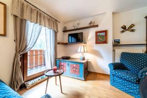 Dolomites Dream Arabba في Masarei: غرفة معيشة مع أريكة زرقاء ونافذة