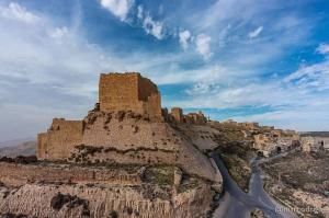 a castle on top of a mountain with a river at mountain view house in Kerak