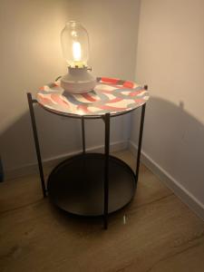 a small table with a lamp on top of it at Zentrale & flexible Unterkunft II in Wilhelmshaven +3 photos