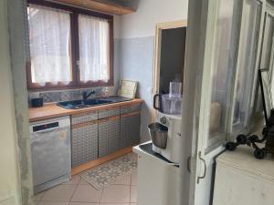 a small kitchen with a refrigerator and a sink at PLIM CIE in Chaponost