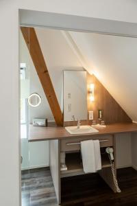 W łazience znajduje się umywalka i lustro. w obiekcie Hotel Hofgut Sternen w mieście Breitnau