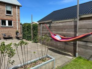 uma rede pendurada numa cerca no quintal em Luxury home Egmond em Egmond aan Zee