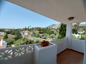 a white balcony with a view of the mountains at casa caravane in Benalmádena